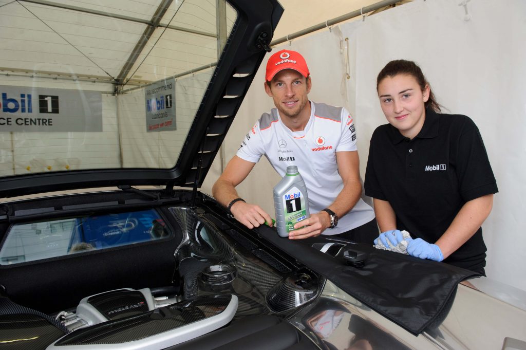 image showing jenson button plus a girl technician and a mclaren demonstrating a bottle of engine oil