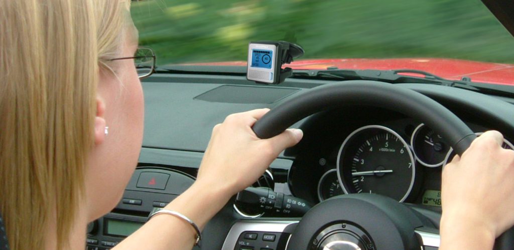image over the shoulder of blonde woman driving a mazda car with a dash camera